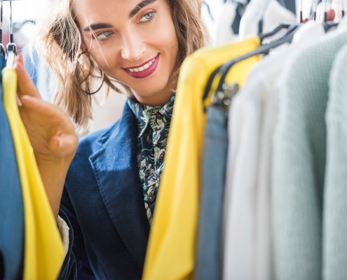 Fashion retailer franchise candidate looking through clothes rack