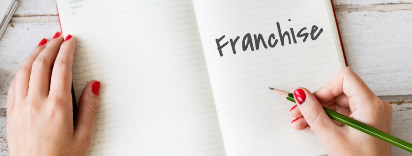 Notebook writing the reasons to franchise a business