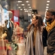 Couple window shopping at a retail franchise store during the holidays