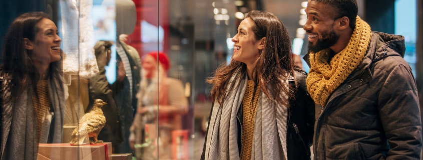 Couple window shopping at a retail franchise store during the holidays